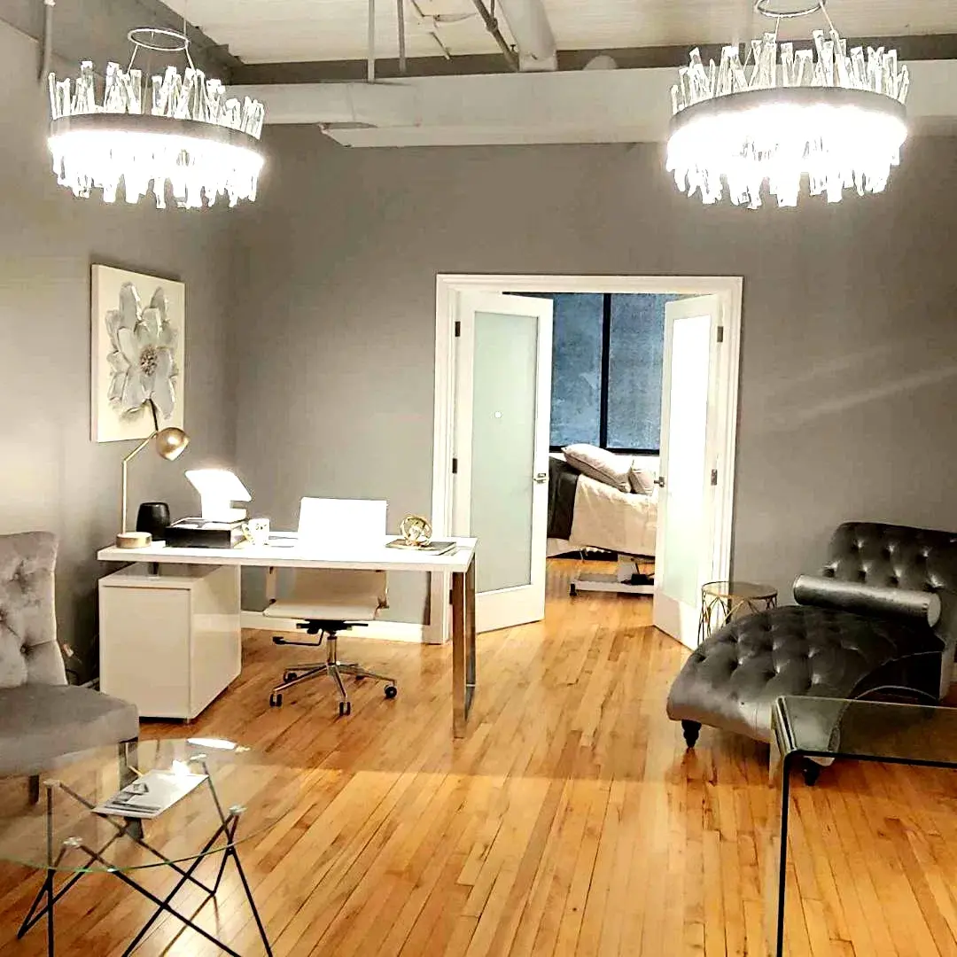 After: finished soft gray walls, white trim, furnished with chandeliers and boutique furniture
