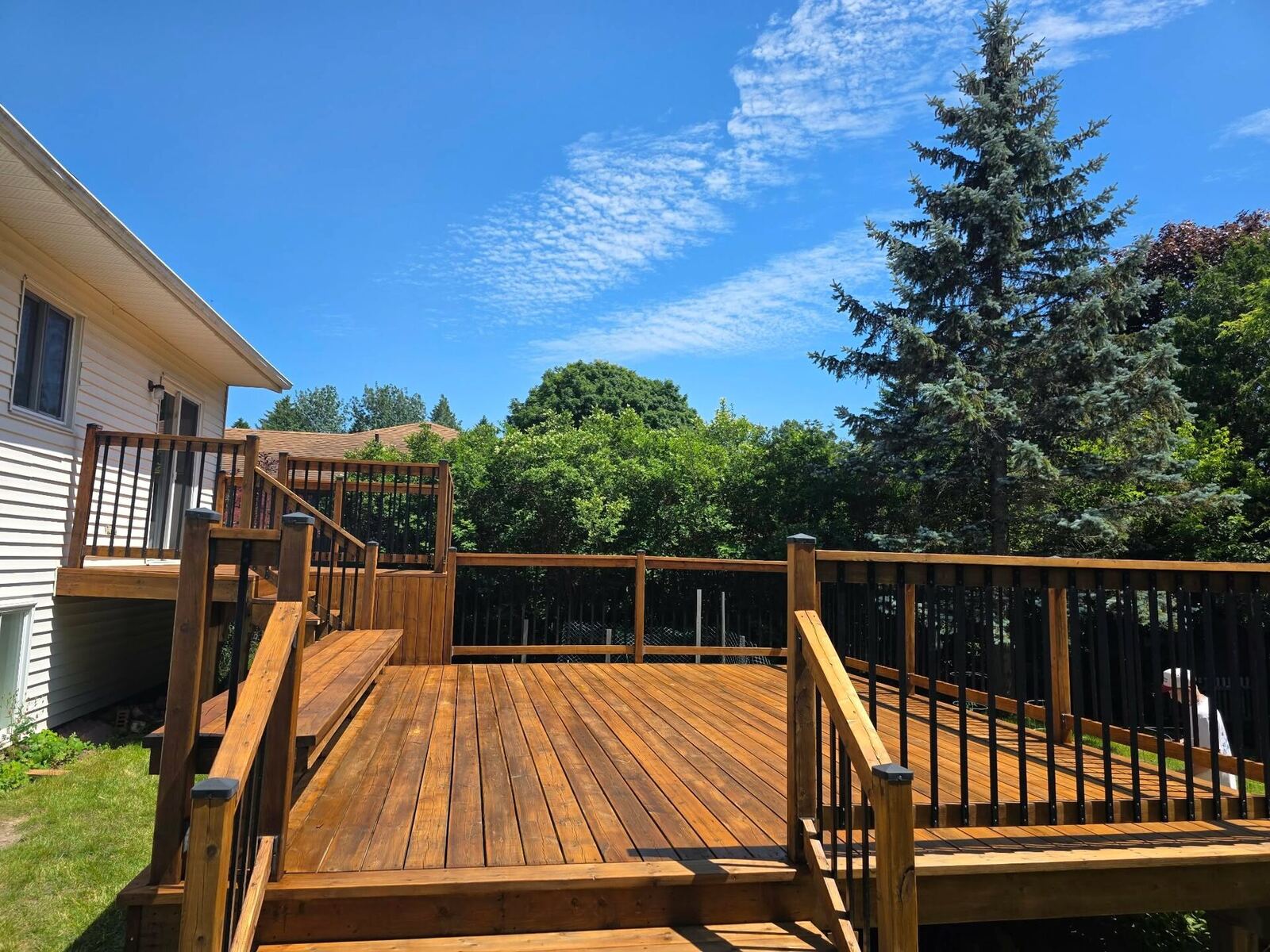 After: same deck sanded and restored with a rich honey-tone stain