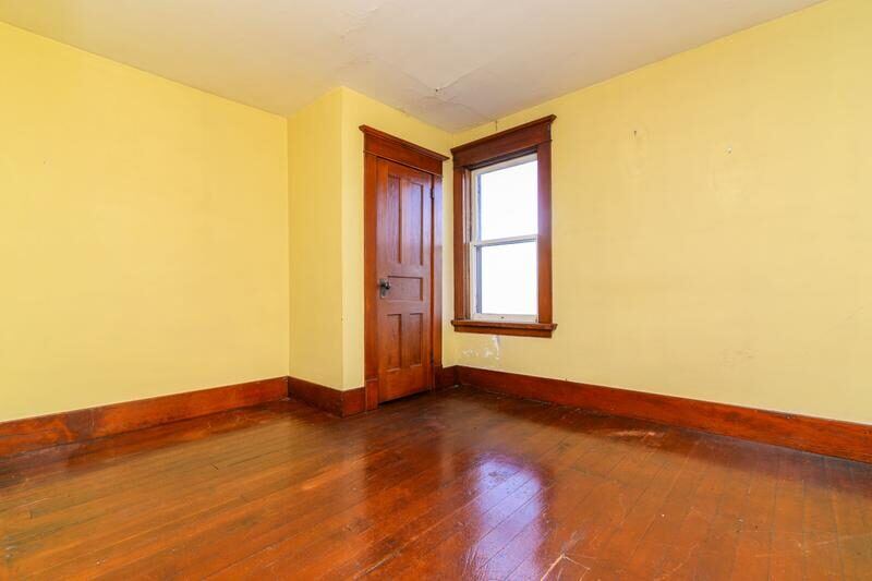 Before: original bare farmhouse room with wood floor and trim