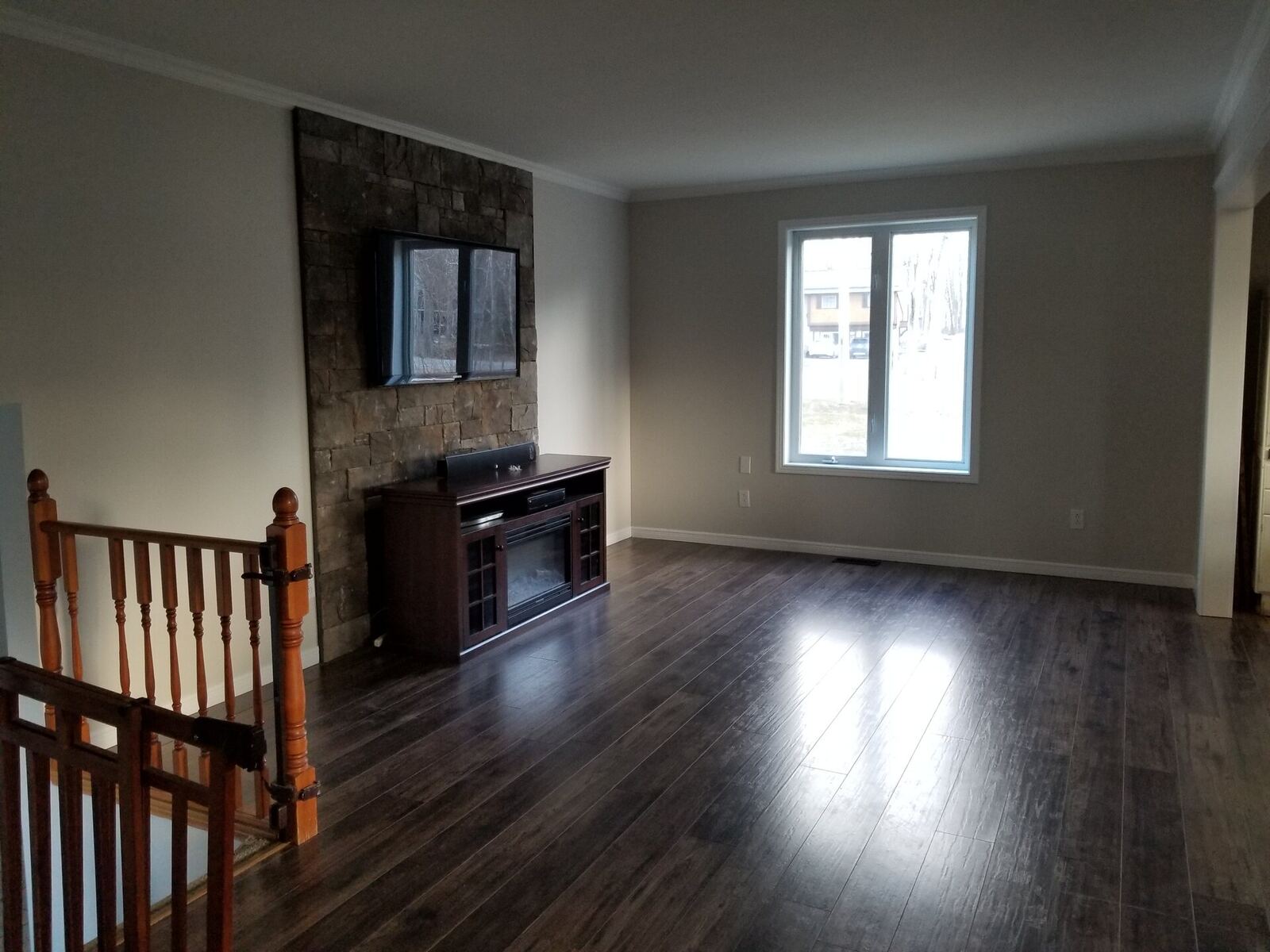 Finished main floor living room, freshly repainted, stone fireplace accent wall